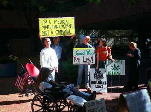 Eddie Smith speaks, while Jim holds a sign above him.